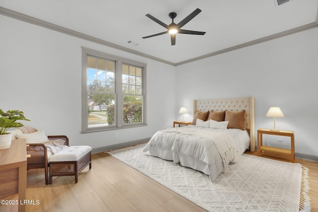 bedroom featuring baseboards, ornamental molding, visible vents, and light wood-style floors