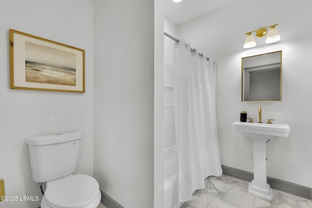 full bath with toilet, marble finish floor, a shower with curtain, and baseboards