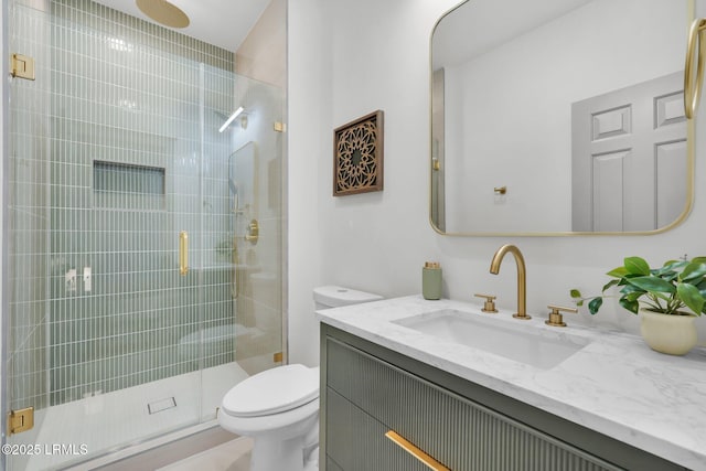 full bathroom featuring a shower stall, toilet, and vanity