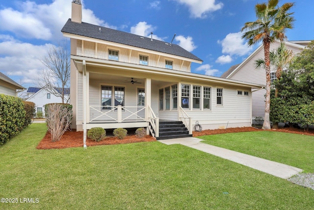 view of front of home featuring a porch, a front lawn, a chimney, and a ceiling fan