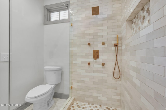 full bathroom with a tile shower and toilet