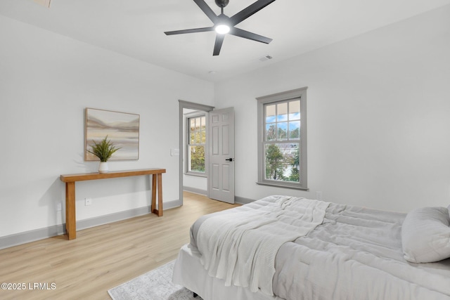 bedroom with light wood-type flooring, baseboards, and visible vents