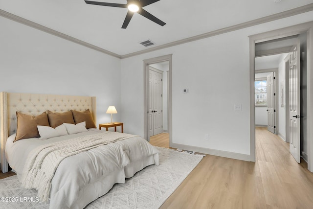 bedroom with crown molding, visible vents, a ceiling fan, light wood-type flooring, and baseboards