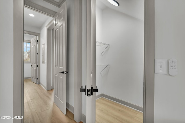 hallway with light wood-style floors and baseboards