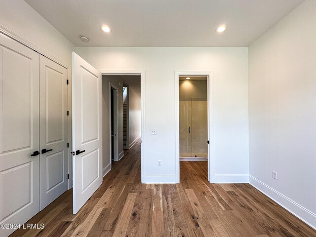 unfurnished bedroom with dark hardwood / wood-style floors and a closet