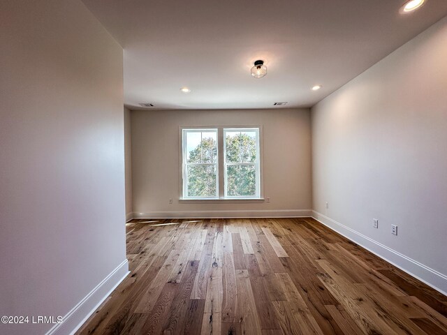 unfurnished room with hardwood / wood-style flooring