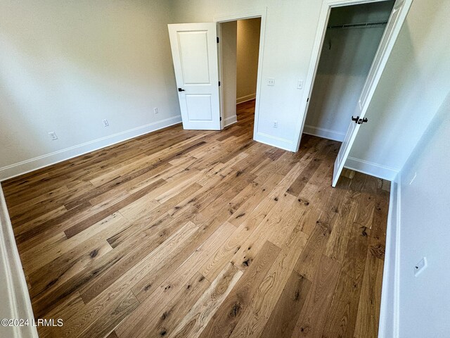 unfurnished bedroom with light hardwood / wood-style floors and a closet