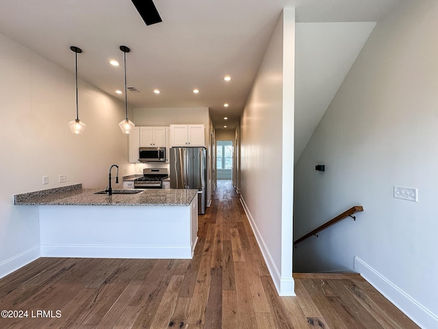 kitchen with appliances with stainless steel finishes, pendant lighting, white cabinetry, sink, and kitchen peninsula