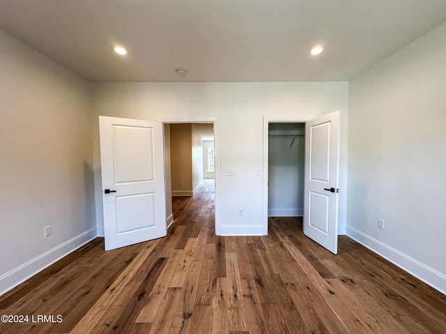 unfurnished bedroom featuring dark wood-type flooring and a closet