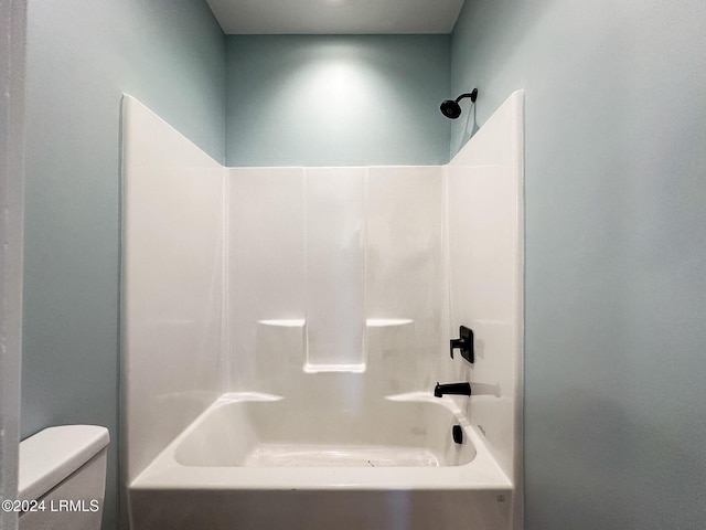 bathroom featuring shower / washtub combination and toilet