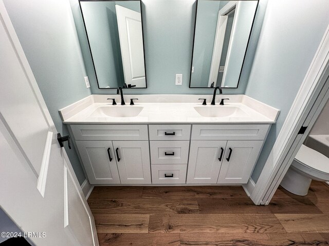 bathroom with vanity, toilet, and hardwood / wood-style floors