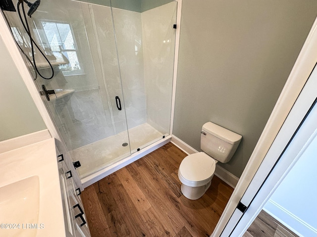 bathroom with an enclosed shower, hardwood / wood-style floors, and toilet