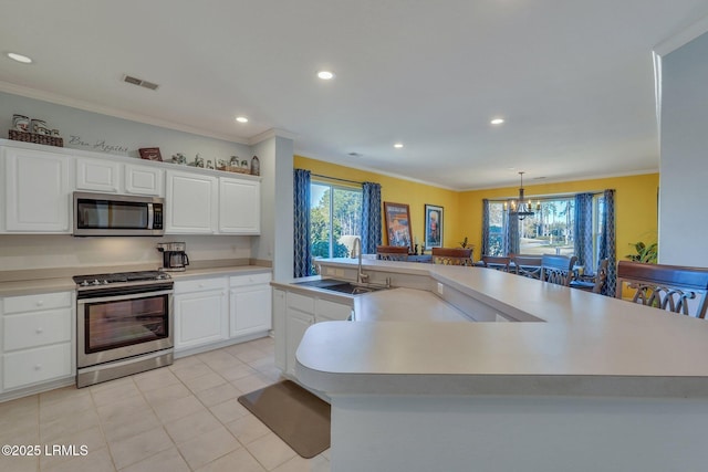 kitchen featuring sink, appliances with stainless steel finishes, white cabinetry, plenty of natural light, and a large island with sink