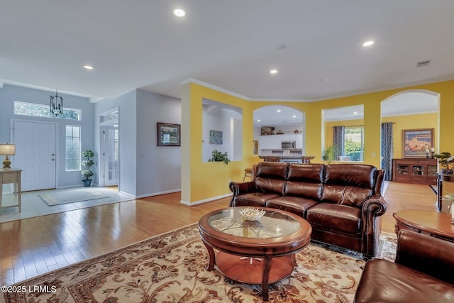 living room with crown molding and light wood-type flooring