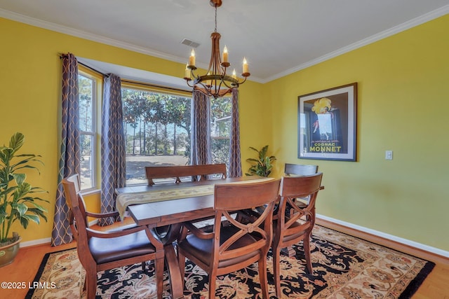 dining room featuring an inviting chandelier, hardwood / wood-style floors, and crown molding