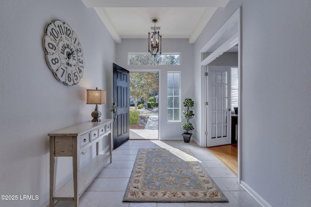 tiled foyer with a notable chandelier