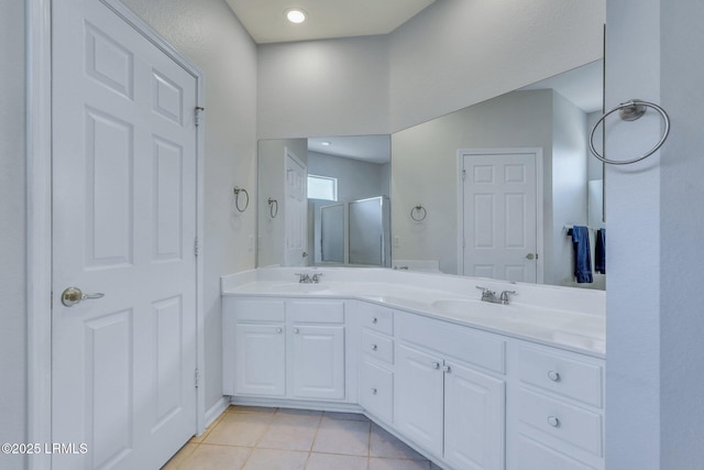 bathroom featuring tile patterned flooring, vanity, and a shower with door