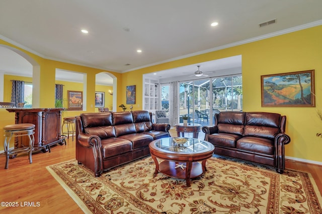 living room with crown molding and light hardwood / wood-style floors