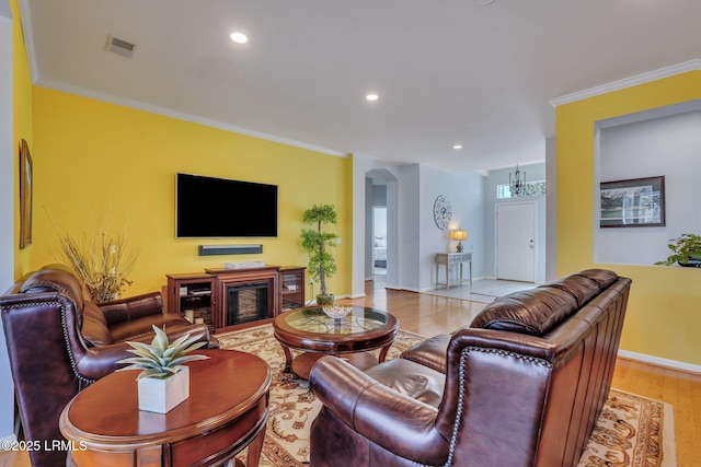 living room with crown molding and light hardwood / wood-style flooring