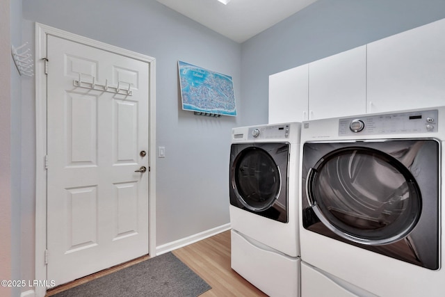 laundry area featuring cabinets, washer and dryer, and light wood-type flooring