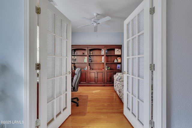 office with ceiling fan, light wood-type flooring, and french doors