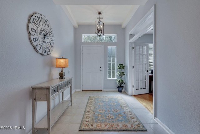 tiled entrance foyer with a notable chandelier