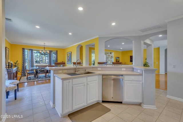 kitchen with an island with sink, dishwasher, sink, and white cabinets