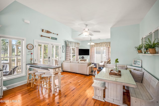 dining room featuring baseboards, ceiling fan, french doors, and light wood-style floors