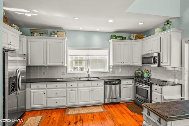 kitchen with dark countertops, a sink, and stainless steel appliances