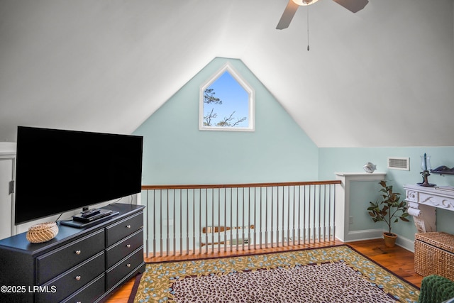 bedroom featuring a ceiling fan, wood finished floors, lofted ceiling, and visible vents