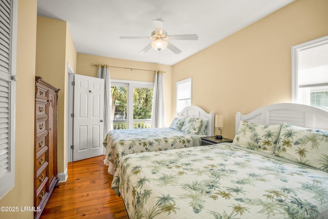 bedroom with multiple windows, a ceiling fan, and wood-type flooring