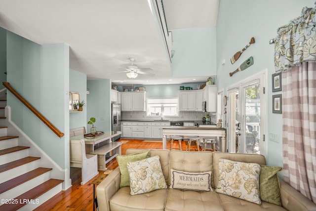 living area with stairs, recessed lighting, light wood-style floors, and a ceiling fan