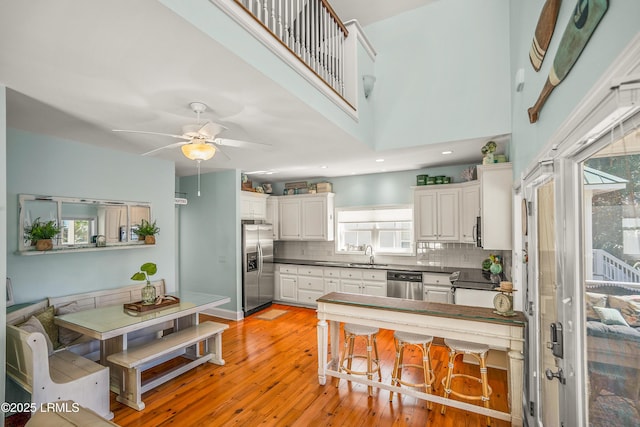 kitchen featuring a sink, dark countertops, backsplash, and appliances with stainless steel finishes