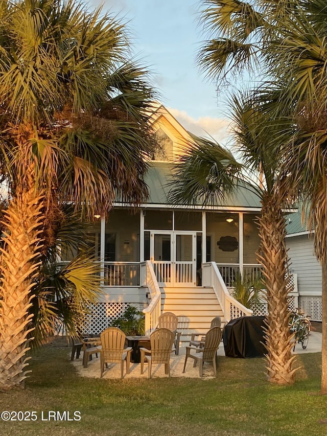 back of house with a sunroom, a yard, and a patio area