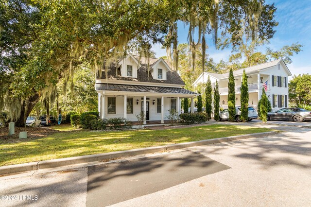 cape cod home featuring a porch and a front yard