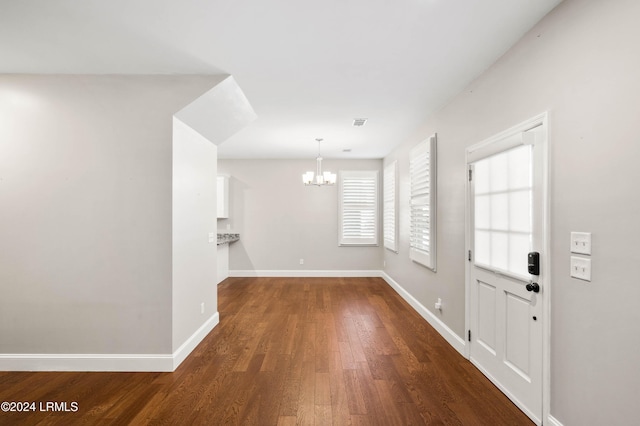 entrance foyer with dark hardwood / wood-style flooring and a chandelier