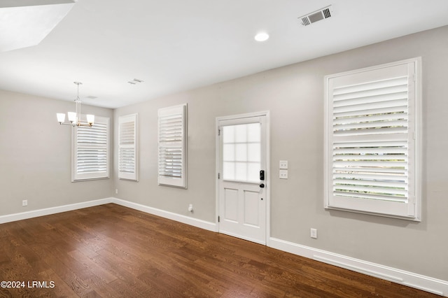 foyer entrance featuring dark hardwood / wood-style floors and a notable chandelier