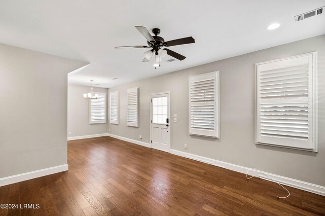 interior space with dark hardwood / wood-style floors and ceiling fan with notable chandelier