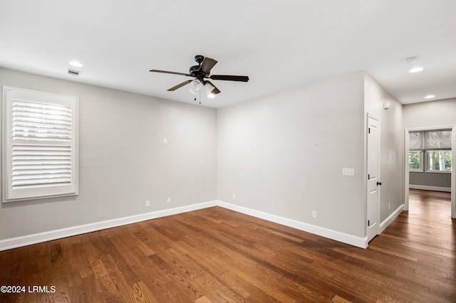 spare room with dark wood-type flooring and ceiling fan