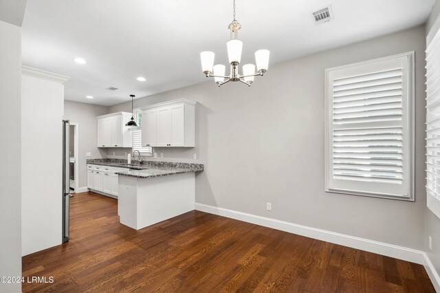 kitchen featuring white cabinetry, dark stone countertops, sink, and pendant lighting