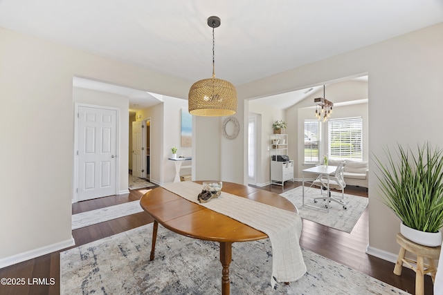 living room with baseboards, wood finished floors, and an inviting chandelier