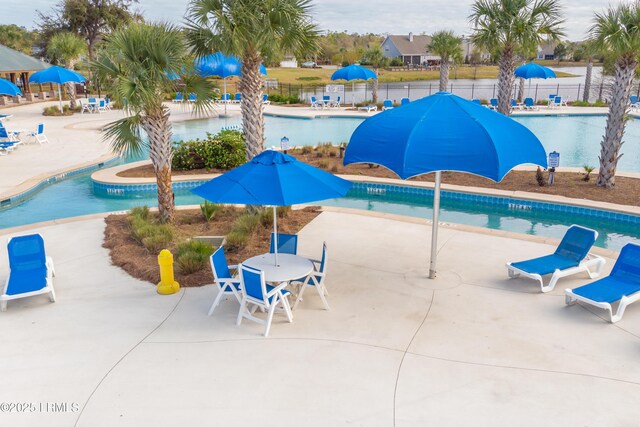 pool featuring fence, outdoor dining space, and a patio