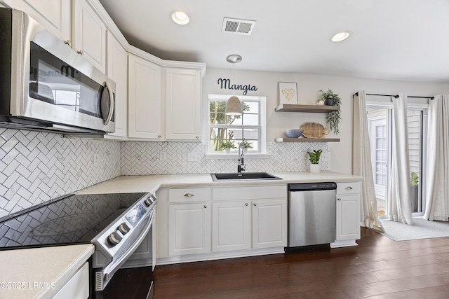kitchen featuring white cabinetry, a sink, appliances with stainless steel finishes, visible vents, and light countertops