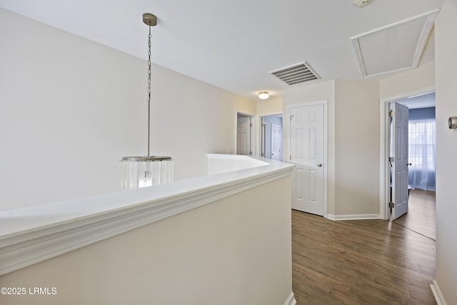 hall with dark wood-style floors, visible vents, and baseboards