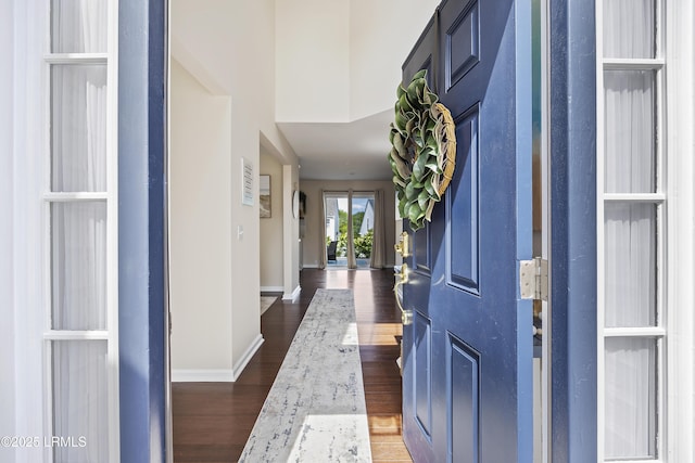 entrance foyer with dark wood-type flooring and baseboards