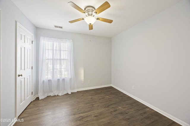 unfurnished bedroom with a ceiling fan, visible vents, baseboards, and dark wood finished floors