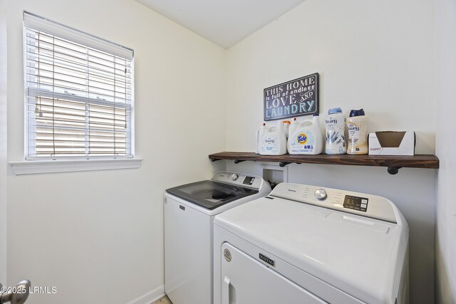 washroom with baseboards, washing machine and clothes dryer, and laundry area