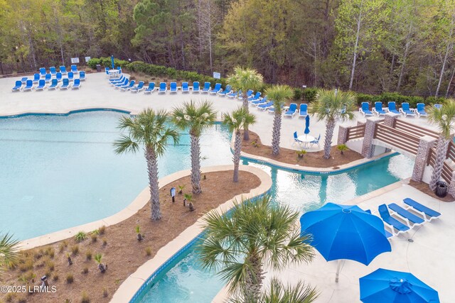 community pool featuring a patio area and a forest view