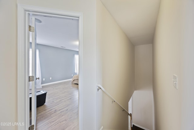 staircase featuring baseboards and wood finished floors