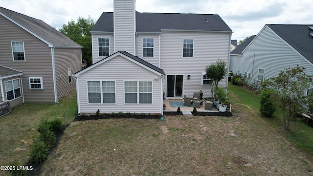 rear view of house featuring a lawn, a chimney, a patio area, and an outdoor living space